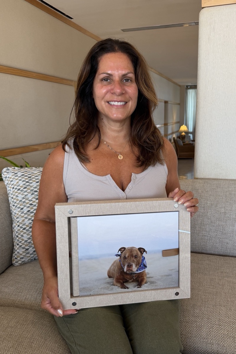 Nicole Carlucci holds framed beach artwork of her dog
